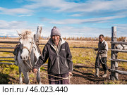 Лошади и их хозяева ( отец и сын - потомственные коневоды ) на коневодческом фермерском хозяйстве , что у якутского села Томтор ( Республика САХА, Якутия ) Оймяконский район ) (2010 год). Редакционное фото, фотограф Павел Просянов / Фотобанк Лори