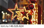 City streets advent Christmas decorations by night. Festive Xmas decor, colorful ornaments in urban setting. Holiday decorations of building or shops glow brightly, shiny stars. Illuminated ornaments. Стоковое AI-видео, аниматор Марина Демидюк / Фотобанк Лори