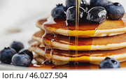Homemade Pancakes stack with blueberries and honey on a modern ceramic plate. Classic blueberry pancake stack filled with syrup among gray concrete wall background. Sweet breakfast with berry, fruit. Стоковое AI-видео, аниматор Марина Демидюк / Фотобанк Лори