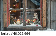Cozy Winter Scene. Snow and a Candlelit Window, Embracing the Serenity of Season. Warm, inviting window view with Christmas lights. Snowflakes and flickering candles, perfect for winter imagery. Стоковое AI-видео, аниматор Марина Демидюк / Фотобанк Лори