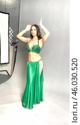 Graceful belly dance performance by a stunning woman in a green outfit. Стоковое видео, видеограф Гурьянов Андрей / Фотобанк Лори