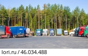 Multicolored trucks stand in a row in a parking lot, long distance cargo transportation. Стоковое фото, фотограф Коханова Наталья / Фотобанк Лори