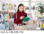 Woman scanning fabric softener in store. Стоковое фото, фотограф Яков Филимонов / Фотобанк Лори