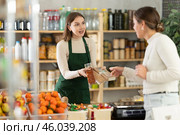 Female seller offers to buy nougat to woman in interior of grocery supermarket. Стоковое фото, фотограф Яков Филимонов / Фотобанк Лори