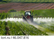 Tractor spraying pesticides on soybean field during agricultural treatment. Стоковое AI-изображение, AI-художник Иван Рябоконь / Фотобанк Лори