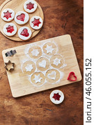 Wooden cutting board with powdered sugar and Linzer cookies, baking decoration process. Стоковое фото, фотограф Ирина Буракова / Фотобанк Лори
