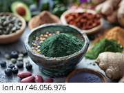Variety of superfoods in bowls on a table representing healthy eating and wellbeing. Стоковое AI-изображение, AI-художник Иван Рябоконь / Фотобанк Лори