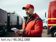 Truck driver doing vehicle inspection and writing on clipboard. Стоковое AI-изображение, AI-художник Иван Рябоконь / Фотобанк Лори