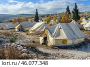 Refugee camp with tents providing shelter for displaced people. Стоковое AI-изображение, AI-художник Иван Рябоконь / Фотобанк Лори
