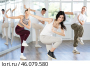 Happy dark-haired girl practicing vigorous zumba in fitness studio. Стоковое фото, фотограф Яков Филимонов / Фотобанк Лори