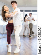 Girl paired up with young man, they train to perform slow waltz dance, rehearse performance. Стоковое фото, фотограф Яков Филимонов / Фотобанк Лори