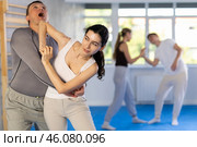 Woman hits man attacker on head during self-defense training session led by trainer. Стоковое фото, фотограф Яков Филимонов / Фотобанк Лори