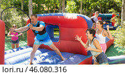Happy man competing with friends in collect hoops on inflatable arena. Стоковое фото, фотограф Яков Филимонов / Фотобанк Лори
