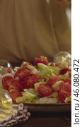Caesar salad with cherry tomatoes and iceberg lettuce, generously topped with croutons. Vertical. Стоковое видео, видеограф Strunov David / Фотобанк Лори