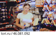 Young woman choosing paint rollers and brushes. Стоковое видео, видеограф Яков Филимонов / Фотобанк Лори