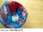 trash bin filled blue garbage bag containing used diapers, symbolizing waste management challenges of parenting. Стоковое фото, фотограф Татьяна Степанищева / Фотобанк Лори