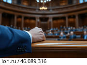 Hand of a man in a blue formalwear on the background of the auditorium. Стоковое AI-изображение, AI-художник Евгений Харитонов / Фотобанк Лори