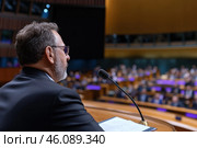 Speaker giving a speech at the conference. Стоковое AI-изображение, AI-художник Евгений Харитонов / Фотобанк Лори