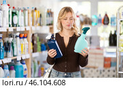 Girl housewife in household store examines goods, chooses glass cleaner spray. Стоковое фото, фотограф Яков Филимонов / Фотобанк Лори