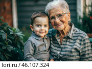 A happy family, a child and a grandmother hug on the street in the park, happy and contented. A grandmother who hugs her grandson, showing love. Стоковое AI-изображение, AI-художник Photojuli / Фотобанк Лори