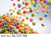 Colorful dragee candies in the assortment on a white background. Various sweets, confectionery and dragees of different shapes and colors. Bright rainbow hues. Стоковое AI-изображение, AI-художник Photojuli / Фотобанк Лори