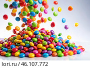 Colorful dragee candies in the assortment on a white background. Various sweets, confectionery and dragees of different shapes and colors. Bright rainbow hues. Стоковое AI-изображение, AI-художник Photojuli / Фотобанк Лори