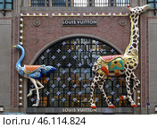 Louis Vuitton’s new NYC flagship. Facade of Art Deco building adorned with giant ostrich and giraffe against backdrop of twinkling Vuitton Monogram flowers. Редакционное фото, фотограф Валерия Попова / Фотобанк Лори