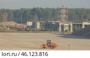 Orange road roller standing on a flat construction site. Стоковое видео, видеограф Константин Шишкин / Фотобанк Лори