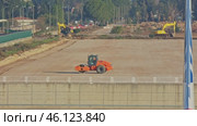 Orange road roller and yellow excavators working on a construction site. Стоковое видео, видеограф Константин Шишкин / Фотобанк Лори