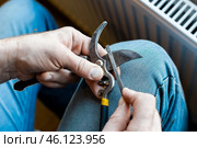 A man sharpens the blade of a garden pruner with a file. Garden tools. Стоковое фото, фотограф Коханова Наталья / Фотобанк Лори