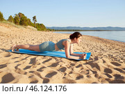 Sporty girl working out on the beach. Fit girl training her abs exercising her core muscles with the plank pose. Стоковое фото, фотограф Виктория Тельминова / Фотобанк Лори