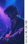 Young male musician playing electric guitar during a concert. Стоковое AI-видео, аниматор Юрий Поздников / Фотобанк Лори