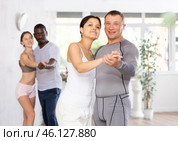 Young Asian woman and European man dancing as couple in dance studio. Стоковое фото, фотограф Яков Филимонов / Фотобанк Лори