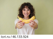 Young cheerful woman hands us a banana. Стоковое AI-изображение, AI-художник Дмитрий Киселёв / Фотобанк Лори