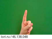 Female hand making warning gesture on Chroma key. Human hand showing her denial with index finger motion isolated on green. Stop sign, refusal, caution. Preventing subsequent problems. Body language. Стоковое фото, фотограф Марина Демидюк / Фотобанк Лори