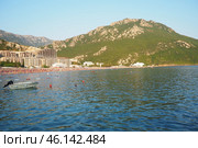Canj, Montenegro 07.20.2024 Boats and a shore with vacationers, sunbathers and swimmers. Hotels, sun umbrellas, Adriatic waves, buoys. Beach tourism. Vacation travel. Summer day. Pebble rock beach. Редакционное фото, фотограф Юлия Петровская / Фотобанк Лори