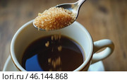 Person adding cane sugar with a spoon to cup of fresh aromatic coffee. Close up of teaspoon putting brown sugar into hot steamed drink mug. Sugar Being Poured into Cup of Coffee Americano, Close-Up. Стоковое AI-видео, аниматор Марина Демидюк / Фотобанк Лори