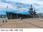 The cruiser "Mikhail Kutuzov", which is a museum ship in the city of Novorossiysk. This Project 68-bis warship was part of the USSR Navy for a long time, and then was turned into a museum, becoming one of the main attractions of the city.The side of the ship with the number "105", which indicates its affiliation with the Navy.You can see the flag garland - a ship decoration used during celebrations.Antennas and radar installations on the masts of the cruiser.A group of tourists on board, inspecting the ship.Mooring ropes secured to the pier.The protective paint of the hull is a characteristic dark gray color. (2023 год). Редакционное фото, фотограф Анна Кривицкая / Фотобанк Лори