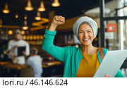 Muslim middle eastern woman in office with raised fist of empowerment, strength and women solidarity, International Womens Day concept. Стоковое AI-изображение, AI-художник Анастасия Золотницкая / Фотобанк Лори