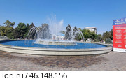 The central fountain of Anapa, located in the city park. Water shoots up from numerous jets, creating a beautiful cascade effect. The fountain is surrounded by a paved area where tourists and locals stroll.On the right you can see a poster for the 32nd Kinoshock film festival, which is traditionally held in Anapa. In the background you can see the building of the Grand Hotel Valentina, as well as green alleys and trees of the city park, creating a cozy atmosphere.The fountain is one of the popular recreation areas, especially on hot summer days, when tourists enjoy the coolness and take beautiful photos. (2023 год). Редакционное фото, фотограф Анна Кривицкая / Фотобанк Лори