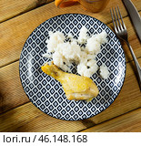 Prepared rice porridge with piece of fried chicken is served on large white platter with bread. Стоковое фото, фотограф Яков Филимонов / Фотобанк Лори