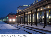 Пригородный поезд Рыбинск-Ярославль у перрона старинного железнодорожного вокзала Рыбинска январским вечером. Редакционное фото, фотограф Виктор Карасев / Фотобанк Лори