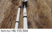 Two gleaming white conduits of engineering infrastructure buried beneath the surface. The site of a project involving the installation of gas, water, and oil pipelines. A close-up view of the camera. Стоковое видео, видеограф Скрипачев Антон / Фотобанк Лори