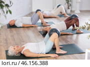 People lying on karemat, pulled bent legs to themselves and clamped soft-ball in knee. Стоковое фото, фотограф Яков Филимонов / Фотобанк Лори