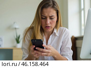 Young woman holding smartphone, worried about online scam, concerned expression, working environment, digital fraud problem, looking upset, technology and security issue. Стоковое AI-изображение, AI-художник Павел Муравьев / Фотобанк Лори