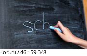 Child Hand Writing Word School on Blackboard. Little Pupil Holds Chalk and Writes on Chalkboard. Стоковое видео, видеограф Марина Демидюк / Фотобанк Лори