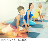 Mother, grandmother and teen son do exercise dove pose, Eka Pada Rajakapotasana. Стоковое фото, фотограф Яков Филимонов / Фотобанк Лори