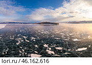 Aerial view on transparent frozen water, violet sunset in background. Beautiful winter landscape with clear blue smooth ice with cracks and mountains. Small Sea, Olkhon, Baikal lake, Siberia, Russia. Стоковое фото, фотограф Алексей Ширманов / Фотобанк Лори