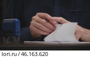 Businessman working on paperwork and stamping approvals, signing documents. close up male hands signing a contract, an agreement. paperwork documentation concept. front view. Стоковое видео, видеограф ЛУНИНА ВЕРОНИКА / Фотобанк Лори