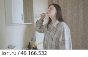 Young woman cares for her dental hygiene in front of the mirror. A bright smile, regular brushing prevents enamel yellowing. Стоковое видео, видеограф Svetlana Golovco / Фотобанк Лори